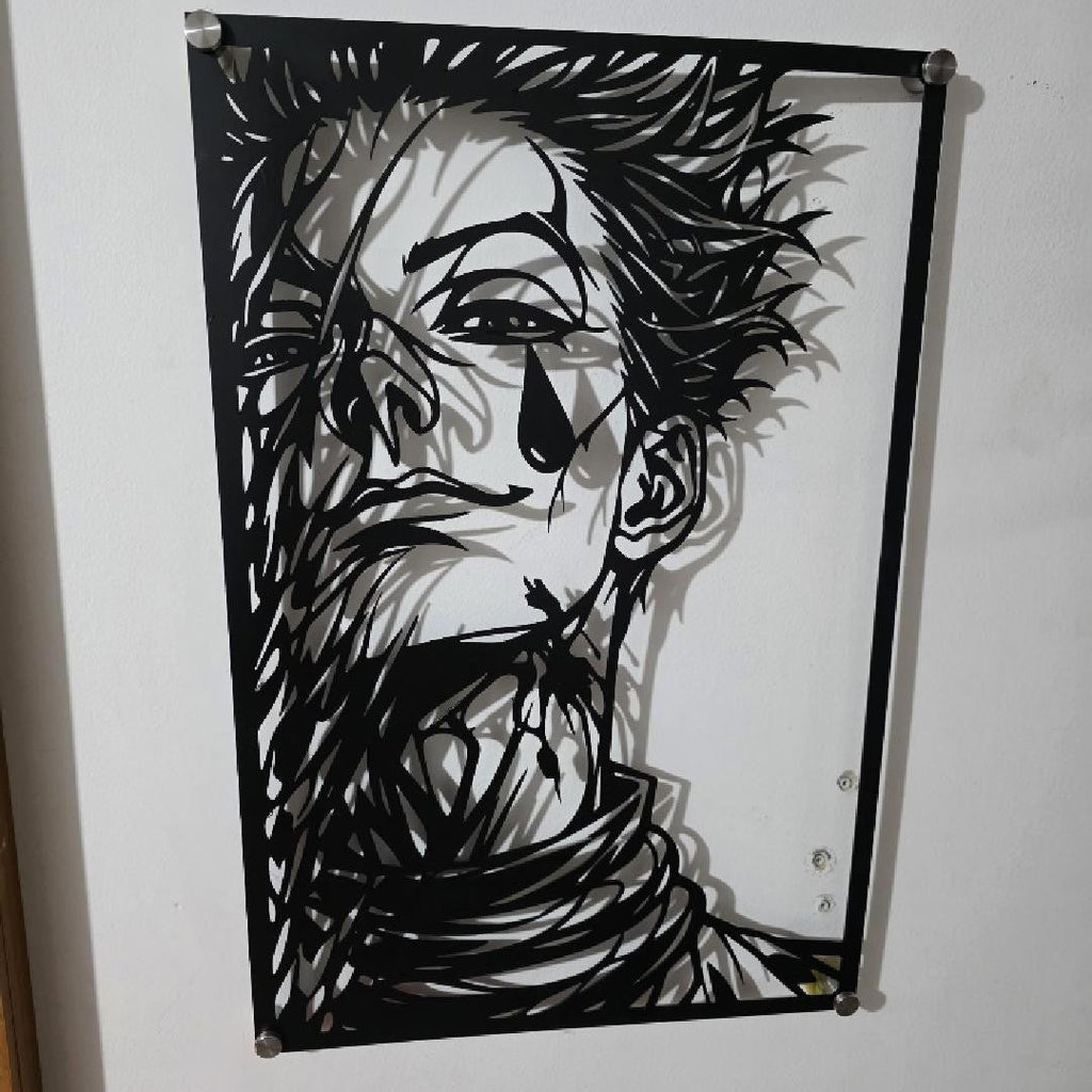 Corte láser y pieza terminada del cuadro de Hisoka Morow en acero, colgado en pared
