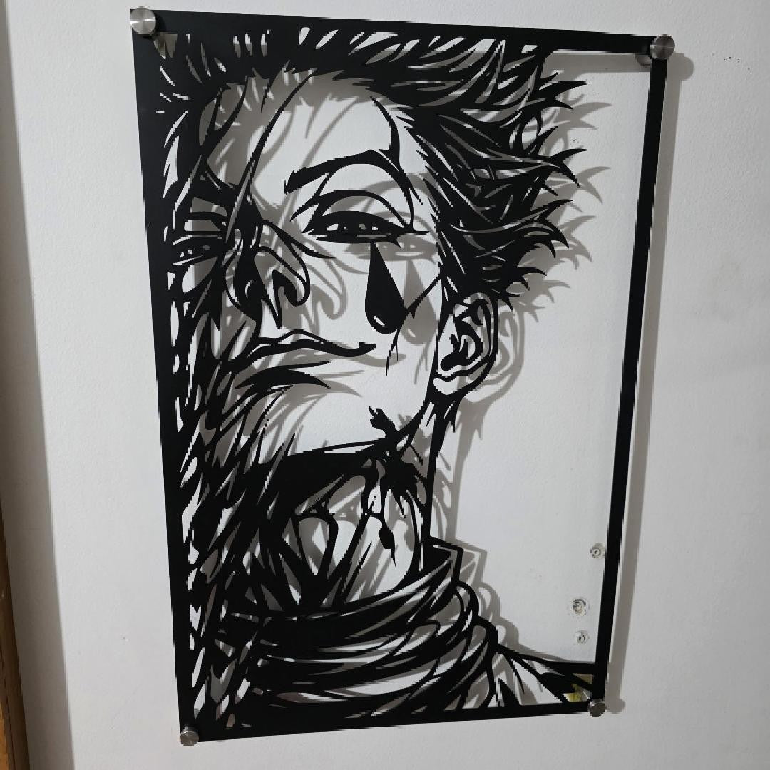 Corte láser y pieza terminada del cuadro de Hisoka Morow en acero, colgado en pared